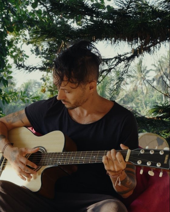 Andrei playing guitar under the trees